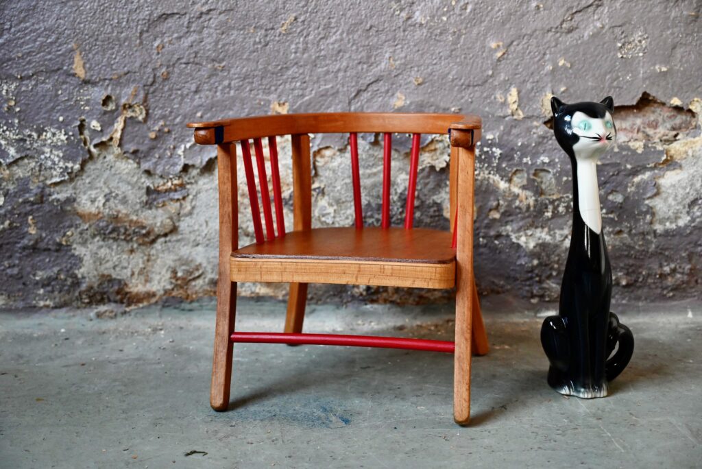 Est-il nécessaire de le présenter? Voici le célèbre fauteuil de propreté Baumann : superbe pièce vintage datant des années 40. Entièrement en bois vernis patiné, les barreaux rouges vifs viennent rendre l'ensemble encore plus charmant et pétillant.