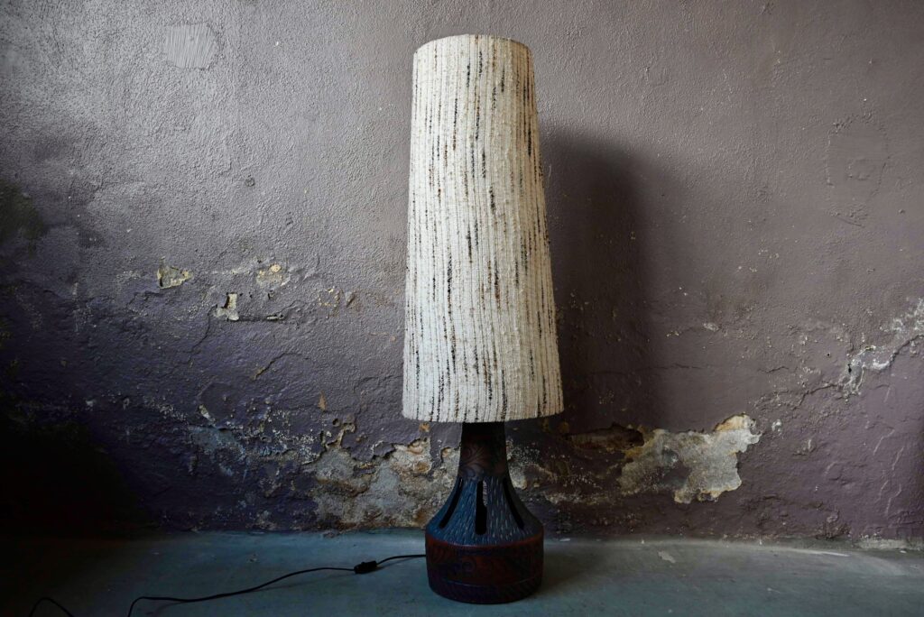 Cette grande lampe vintage est destinée à être posée directement sur le sol. Faite de terre cuite à l'aspect brut ajouré et scarifié .Production vintage,  typique des années 60, c'est une pièce décorative intéressante.