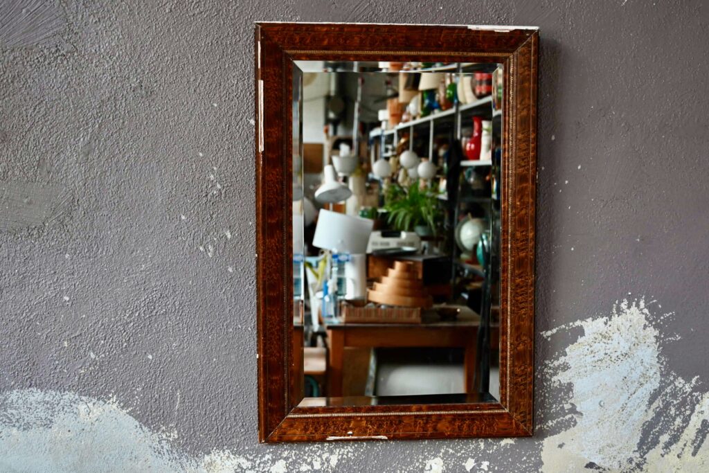 Ce beau miroir rectangulaire possède un cadre en bois rehaussé de stuc et de doré. Il est peint façon marqueterie de ronce. Il est de belles dimensions et possède une patine douce et bohème. Sa glace porte un large biseau.